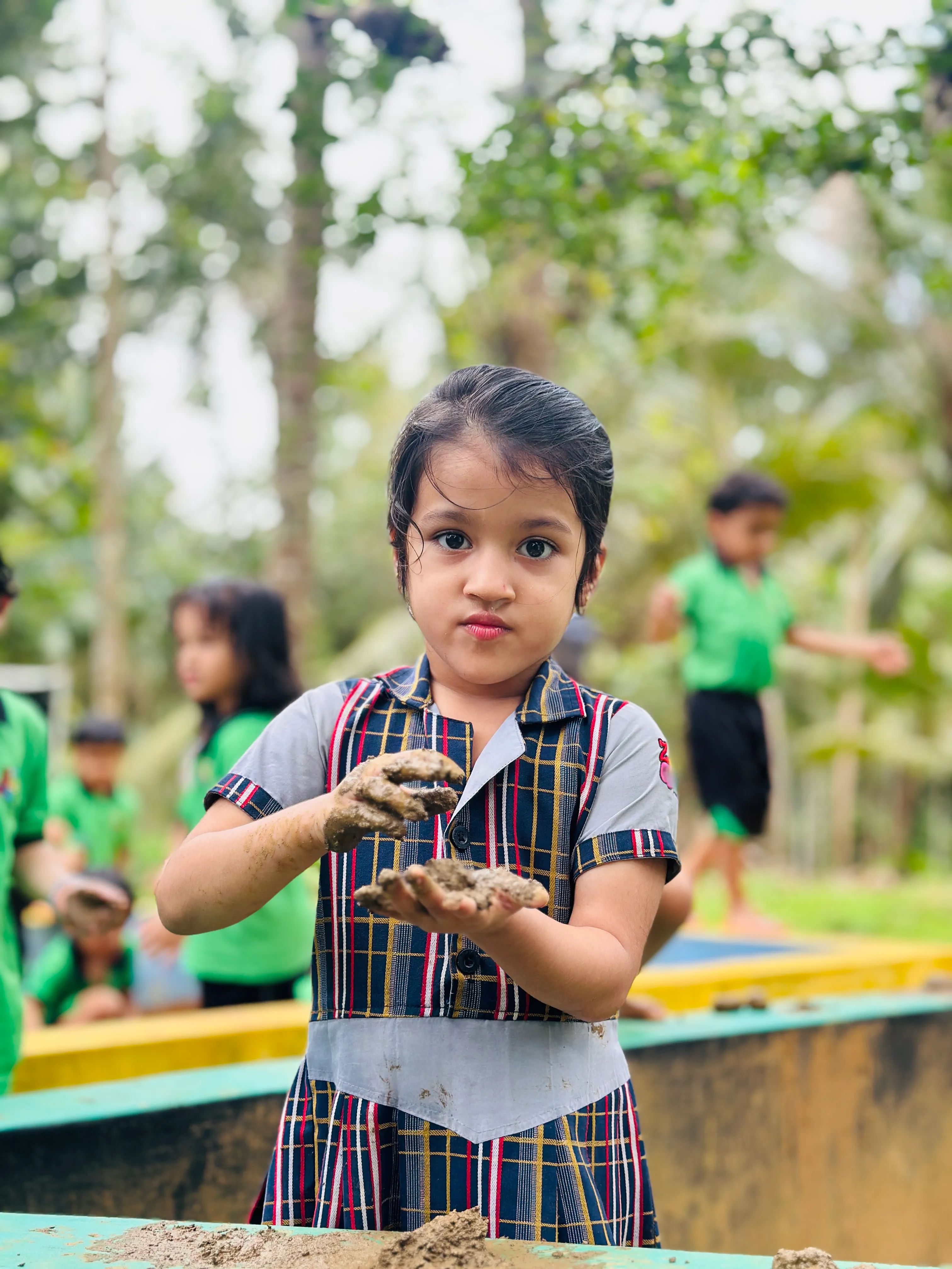 Children dressed in vibrant colors celebrating Colors Day in the campus hall at ZeeQue Preschool in Kerala.